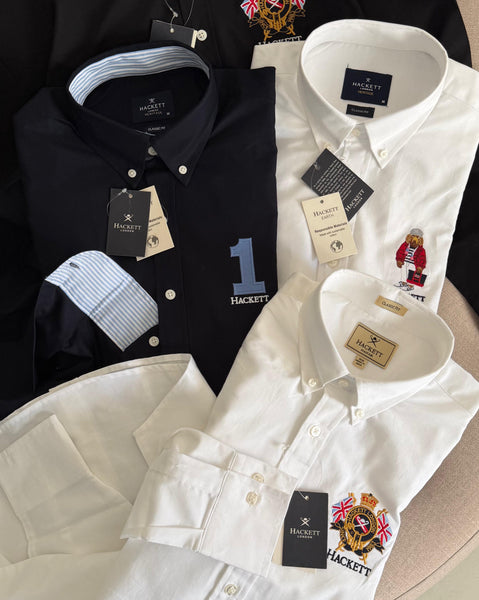 Premium men's shirts collection featuring classic fit button-down shirts in white, black, navy and light blue with embroidered crest, bear and number 1 logo designs