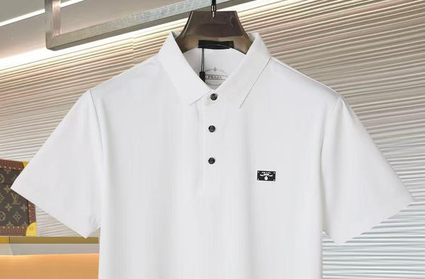 White polo shirt with black buttons and logo on a hanger against a neutral background