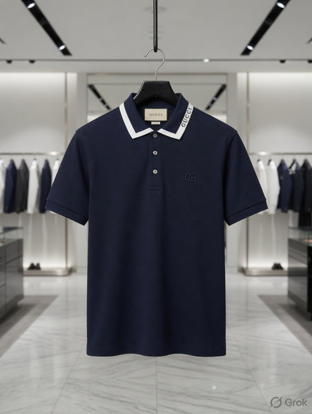 "Branded i men's navy blue short-sleeve piqué polo shirt with white contrast collar stripe T-shirt , Brand text on collar, tonal GG chest logo and metallic placket buttons, displayed on hanger in luxury boutique"
