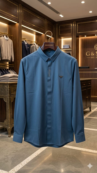 "Man wearing branded  steel blue long-sleeve polo shirt with EA eagle logo badge, inside a luxury Armani boutique"