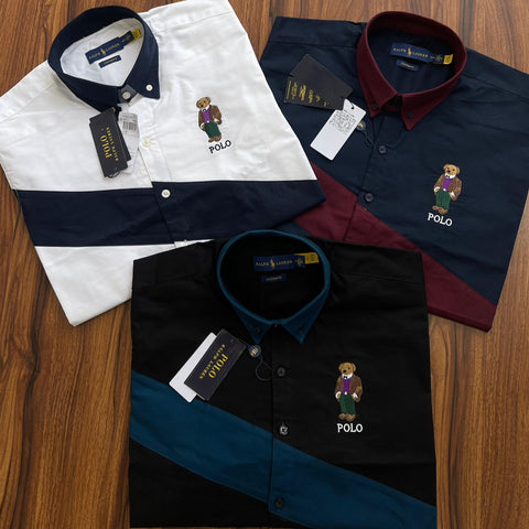 Three Polo shirts with embroidered bear logo on a wooden surface